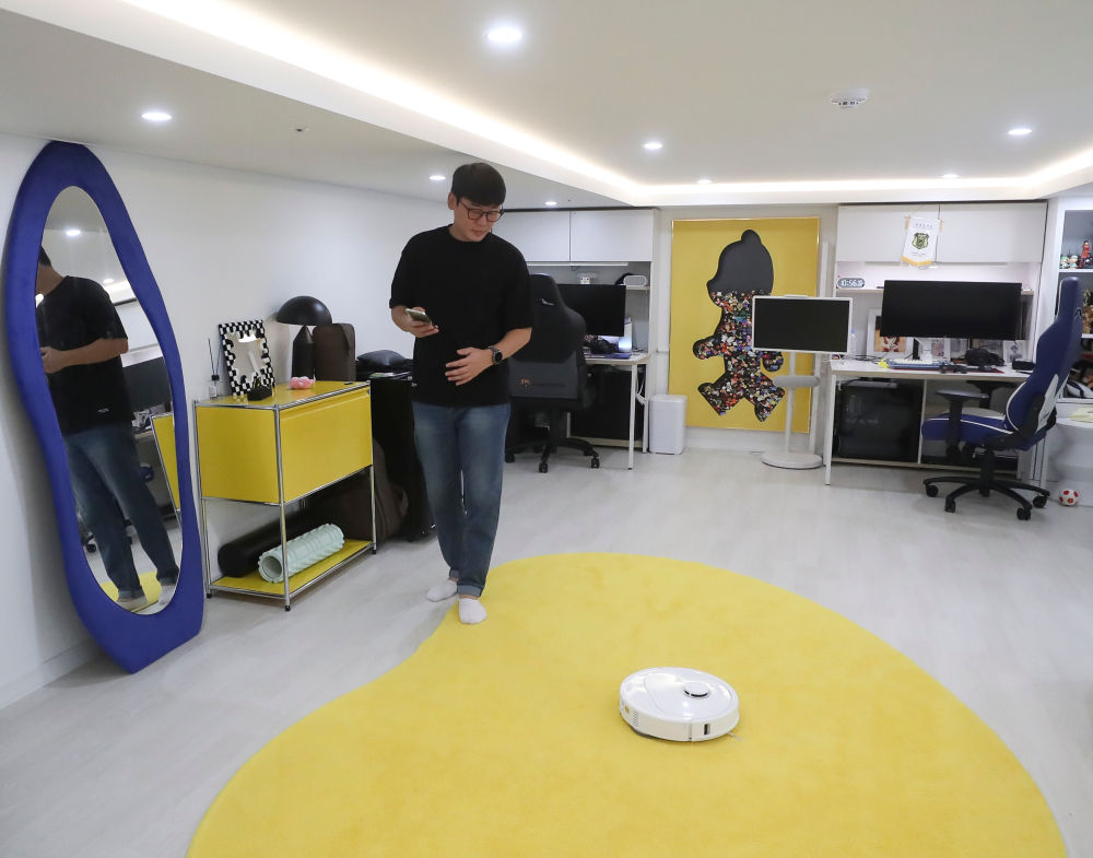 2025年10月13日,韩国消费者在首尔的家中使用扫地机器人。新华社记者 姚琪琳 摄