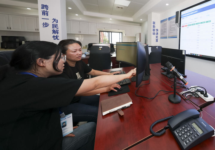 2025年5月12日,在上海市杨浦区殷行街道第五综合网格工作站,工作人员讨论通过“一键呼叫”与居民沟通。新华社记者 王翔 摄