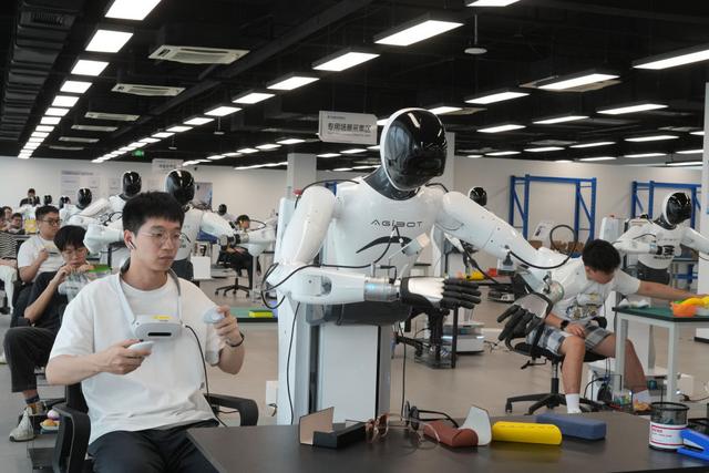 2025年9月23日,在位于浙江绍兴上虞区的杭州湾具身智能创新中心,工作人员操作机器人进行不同场景作业的数据采集。新华社记者 翁忻旸 摄