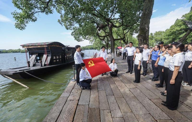 2025年6月30日,新发展党员在浙江省嘉兴市南湖红船旁重温入党誓词。新华社记者 徐昱 摄