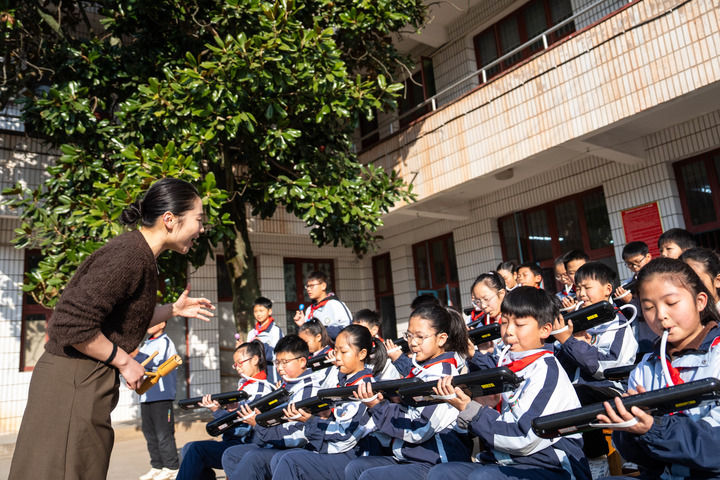 2026年1月13日,在湖南益阳南县三仙湖镇中心小学,音乐老师(左一)指导学生练习口风琴。新华社记者 陈思汗 摄